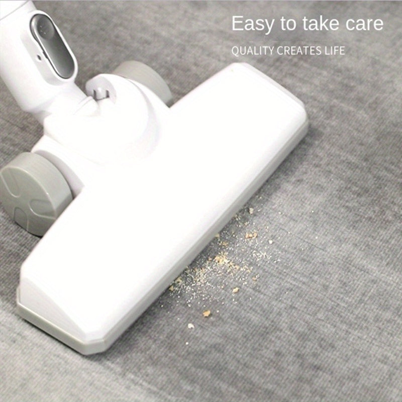 White vacuum cleaner head cleaning carpet with debris - quality cleaning demonstration on gray fabric