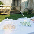 HighPeak Food Tent Cover in white mesh protecting plates of food on outdoor table in backyard setting