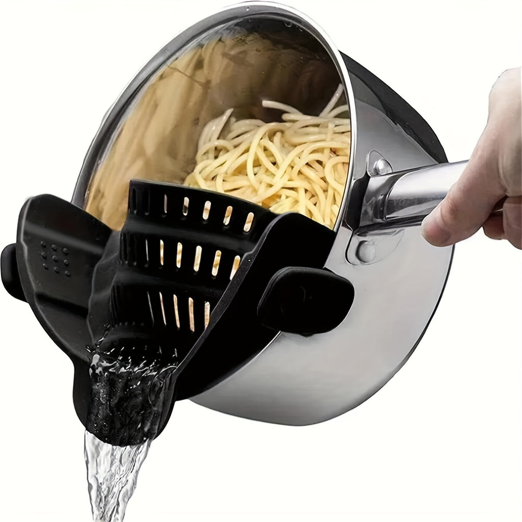 SnapStrain™ - Clip On Food Strainer in black clips onto pot pouring water while draining cooked pasta, kitchen tool for one-hand straining
