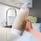 FlipFlow™ - Batter Dispenser in white held in hand with batter inside in a modern kitchen setting by HighPeak