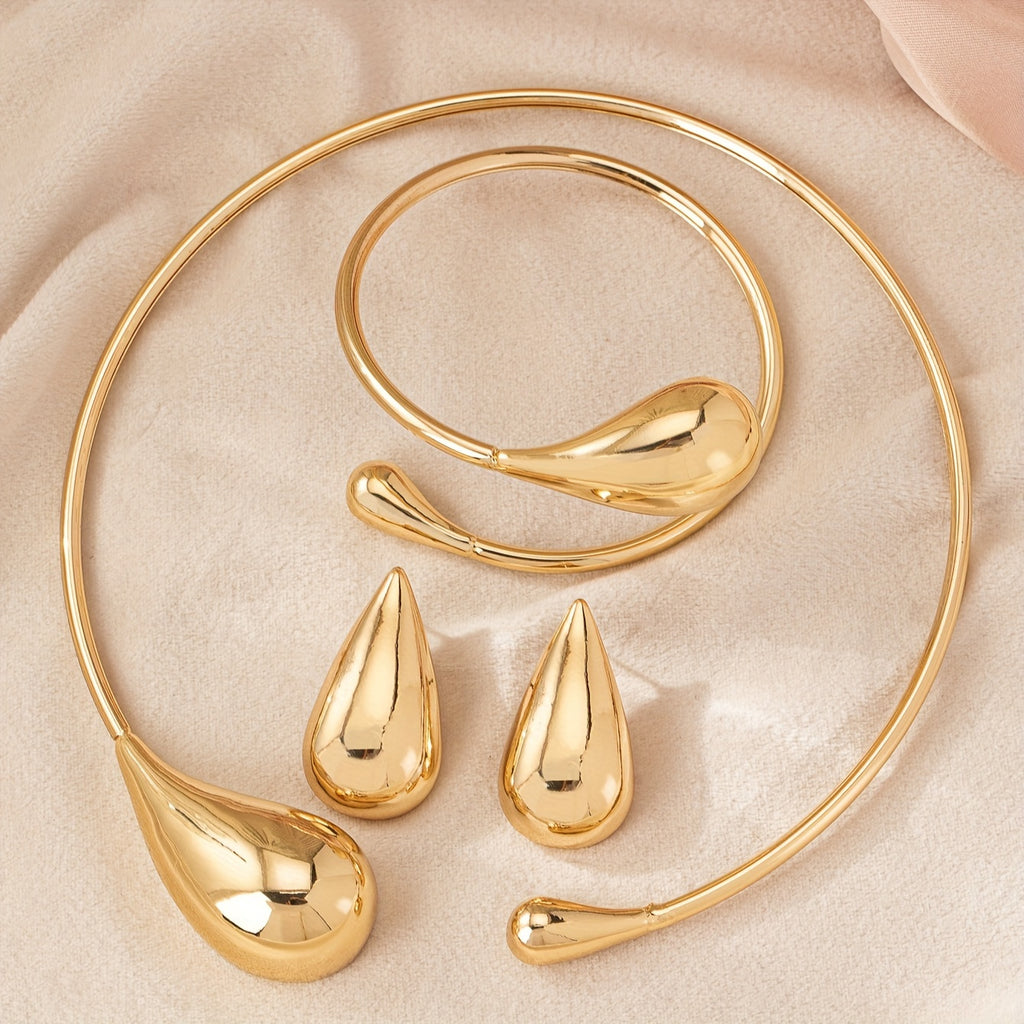 HighPeak Teardrop Jewelry Set in gold with sculpted necklace, bracelet, and earrings on beige fabric background