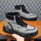 TrailForge™ Boots in gray and black with thick EVA sole and lace-up fit held in hand against a metal mesh background by HighPeak
