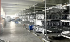 Supplier storage area with long racks of wrapped automotive components and metal frames.