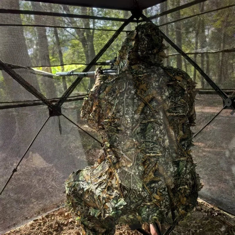 360° One-Way Camo Tent interior with a camouflaged observer looking through panoramic one-way mesh
