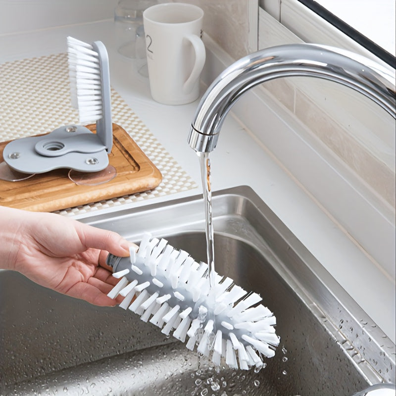 HighPeak TwistClean™ - Cup & Glass Scrubber with white bristles being rinsed under kitchen sink faucet for easy cleaning.