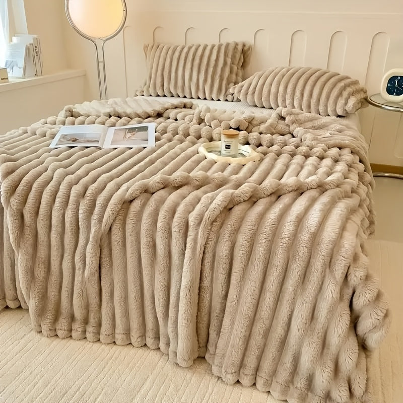 Cozy Fuzzy Blanket in beige ribbed faux fur displayed on bed with matching pillows - plush double-sided texture
