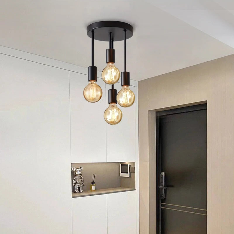 4-Light Ceiling Fixture in black mounted above a modern entryway with staggered warm bulbs