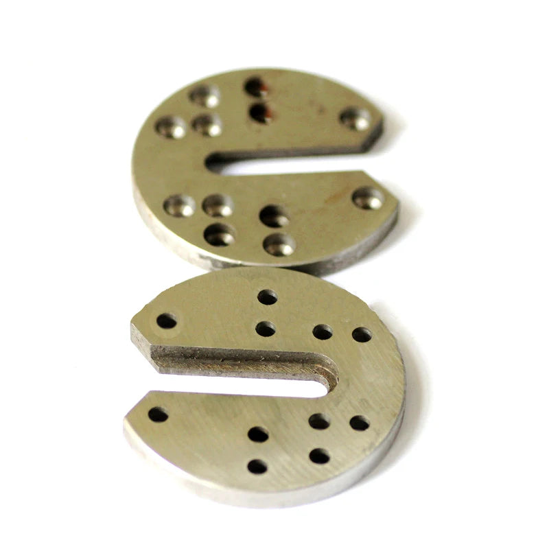 Flat view showing the slots, edges and mounting holes of two metal illusion components