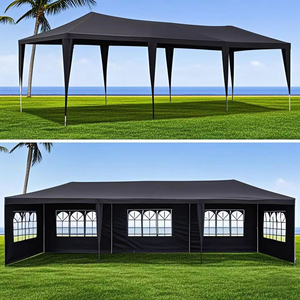 HighPeak Outdoor Party Tent in black 10x30 FT with removable sidewalls and arched windows set on green lawn by the sea