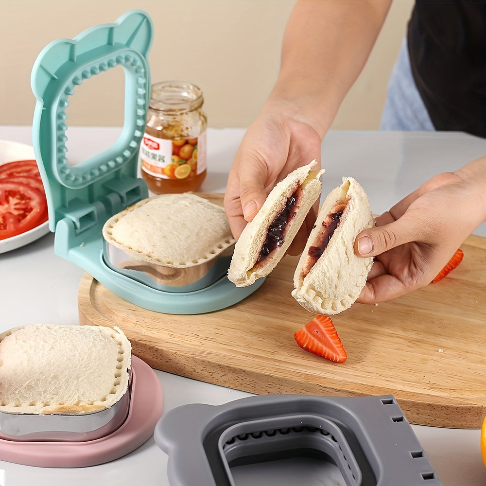 SnackSeal™ DIY Sandwich Cutter in teal sealing crust-free sandwich pockets with jam, held over a wooden board with fruit slices.