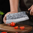 7-Inch Cleaver Chef Knife cutting a cherry tomato, with sliced tomato pieces on the board.
