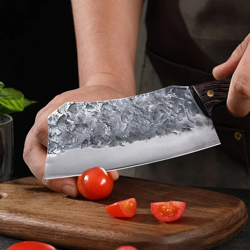 7-Inch Cleaver Chef Knife cutting a cherry tomato, with sliced tomato pieces on the board.