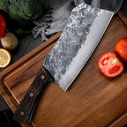 7-Inch Cleaver Chef Knife resting diagonally on a wooden board beside tomatoes and vegetables.
