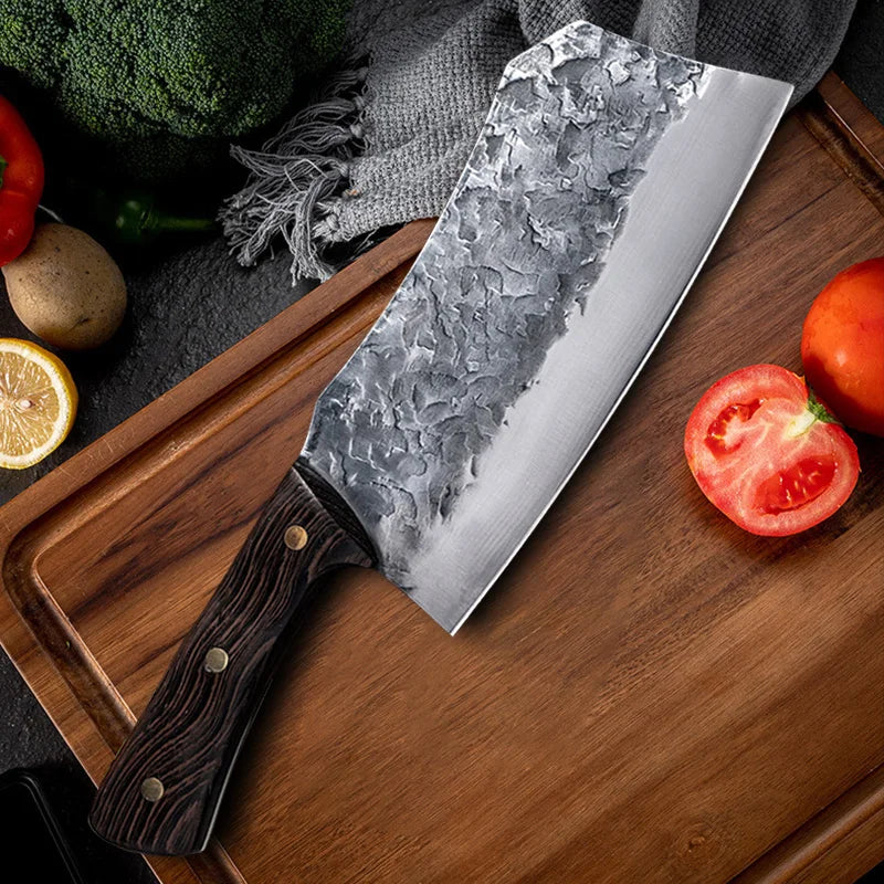 7-Inch Cleaver Chef Knife resting diagonally on a wooden board beside tomatoes and vegetables.