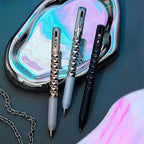 Geometric Metal Crinkle Pen with textured diamond pattern design in silver, black, and rose gold on iridescent surface