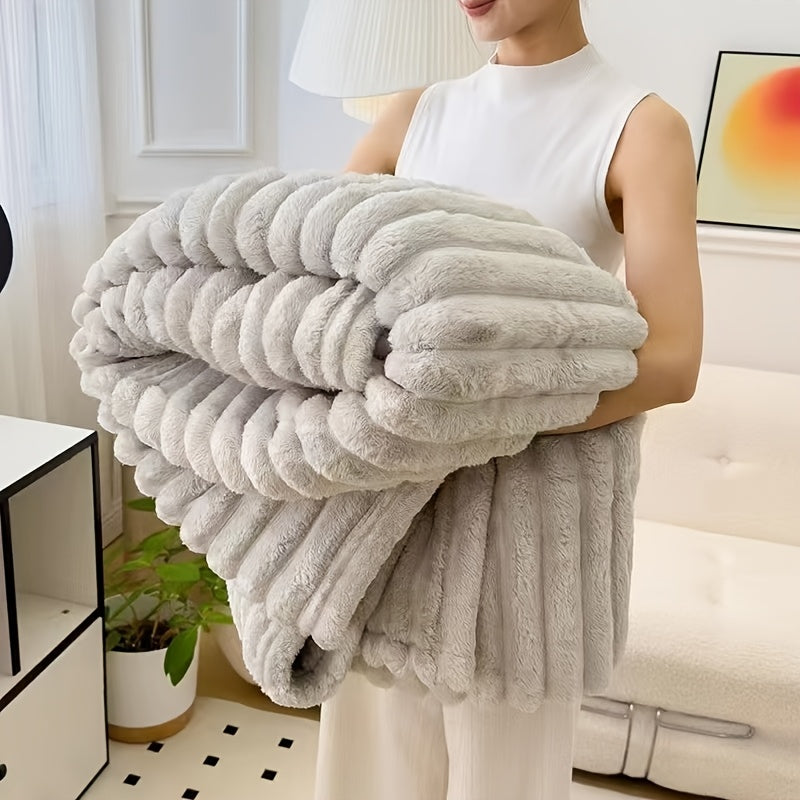 Cozy Fuzzy Blanket in light gray with ribbed texture, folded and held to show plush faux fur texture and double-sided warmth