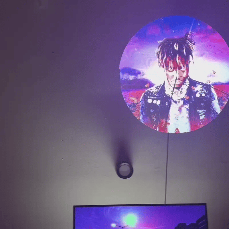 HighPeak AirAura fan displaying vibrant holographic circular image in purple and pink tones against dark wall setting