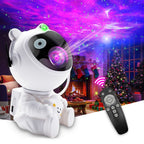 Astronaut Galaxy Projector in white panda design creating purple-blue nebula effects with remote control in cozy Christmas setting