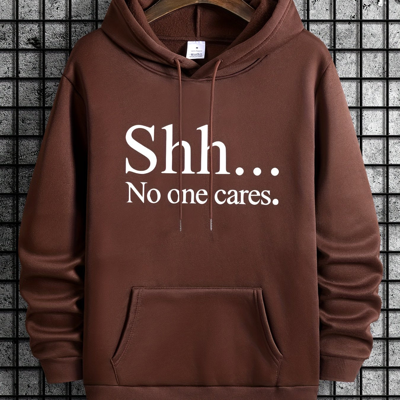 Brown pullover hoodie with "Shh... No One Cares" text in white, featuring kangaroo pocket and classic design