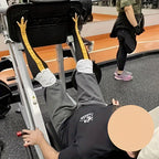 ChickenLegs novelty socks worn at gym, showing yellow chicken feet design on grey socks during workout on exercise bench