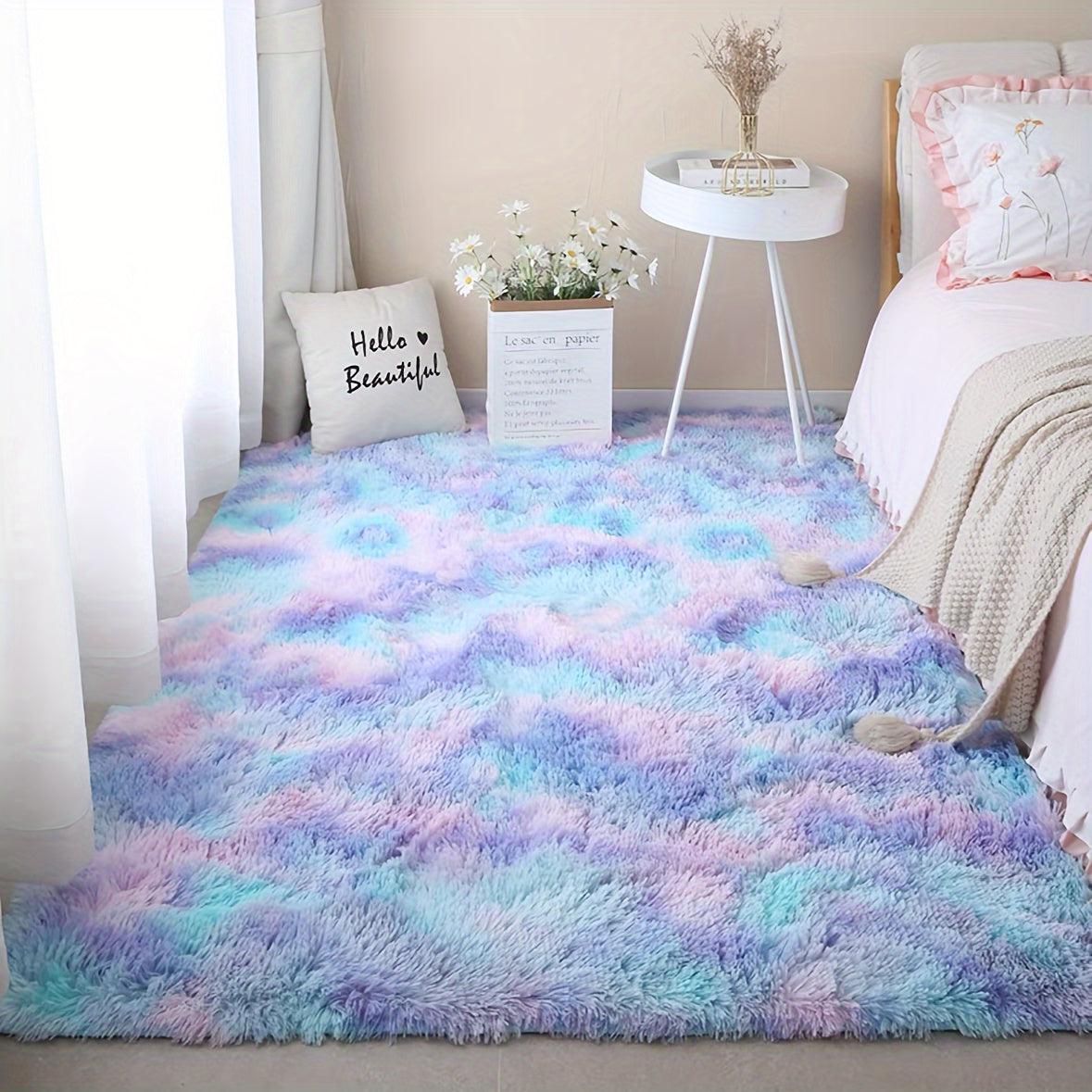 CloudCotton™ Rug in pastel rainbow gradient displayed in cozy bedroom setting with white side table and decorative elements