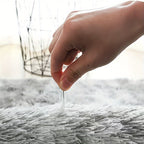 CloudLuxe Ultra-Soft Plush Rug in white being touched to demonstrate its plush texture and softness on carpeted floor