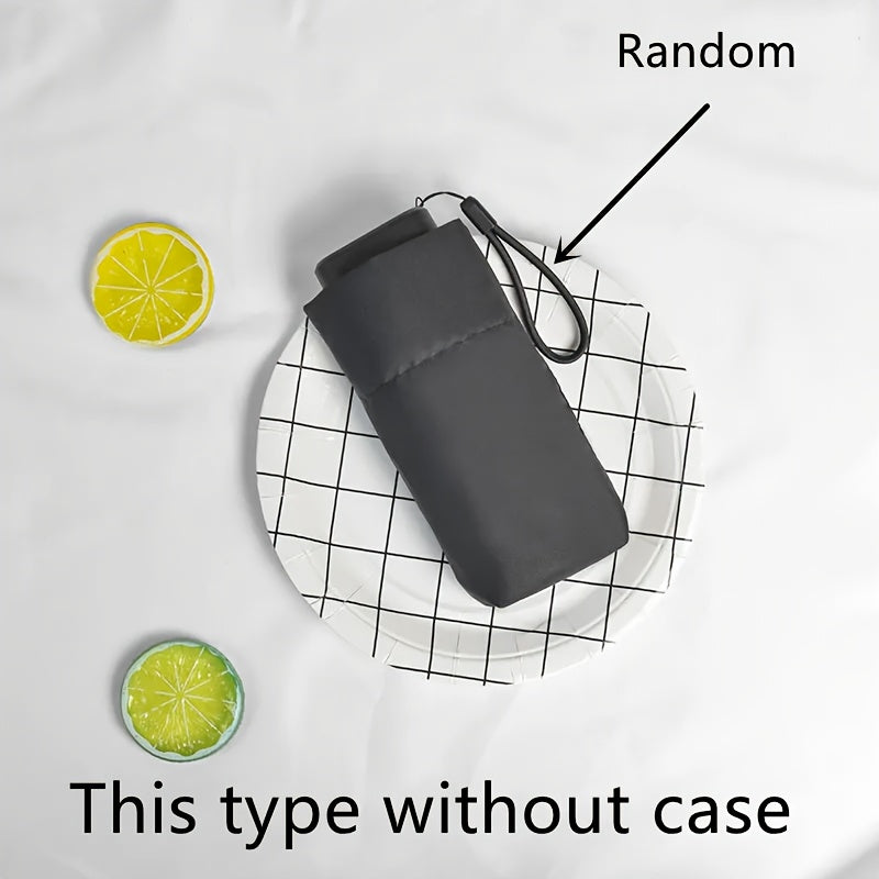 Compact gray Mini Pocket Umbrella on checkered plate with decorative lemon slices, showcasing portable design and storage case