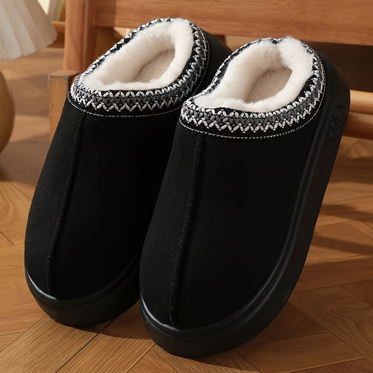 CozyGlide black suede slippers with white fleece lining and nordic trim pattern on wooden floor - cozy indoor footwear