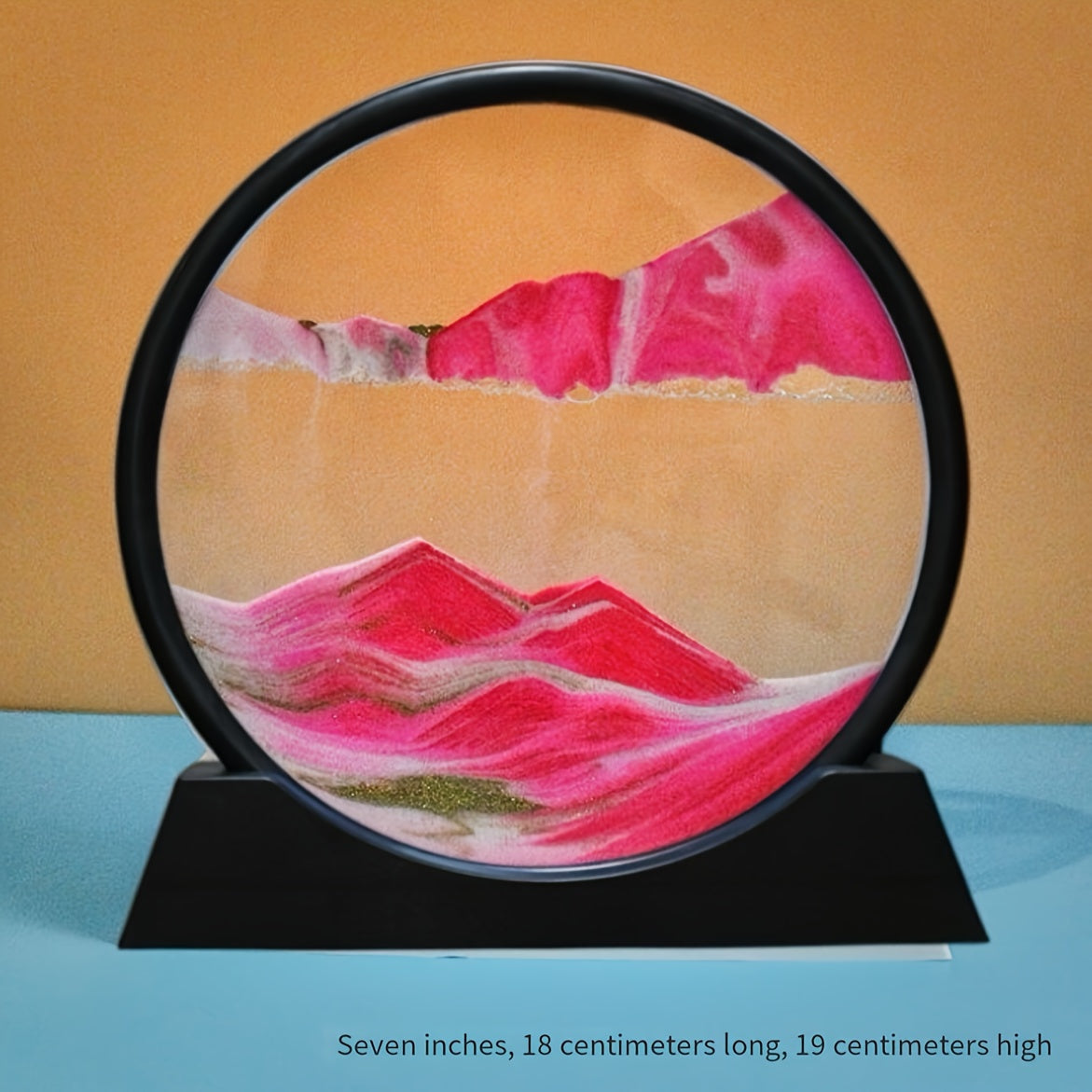 Eclipse Flow Dynamic Sand Art displaying pink sand formations against orange backdrop in circular black frame