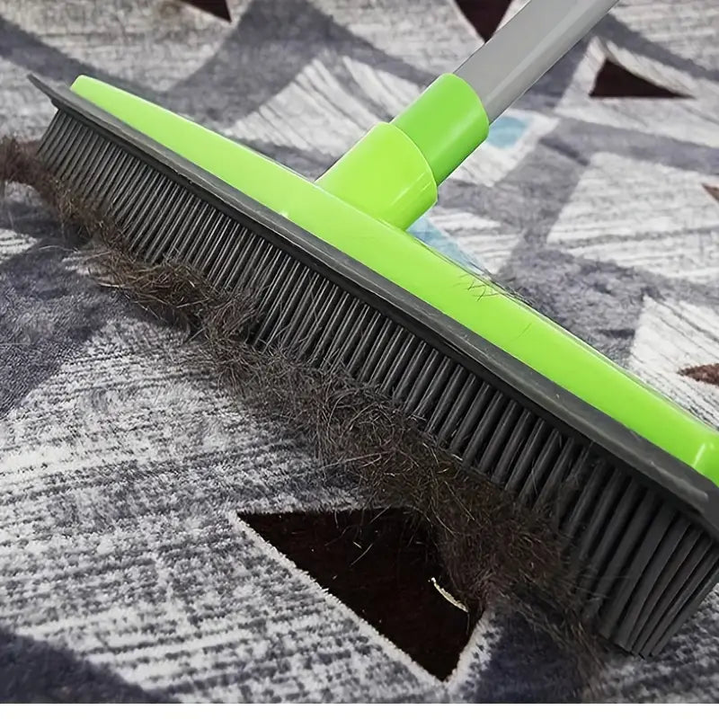 FurSweep Pro broom with rubber bristles in neon green sweeping pet hair from gray patterned carpet - cleaning demonstration