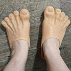 Giant Feet Slippers in beige with realistic toe details and textured design shown worn on grey surface