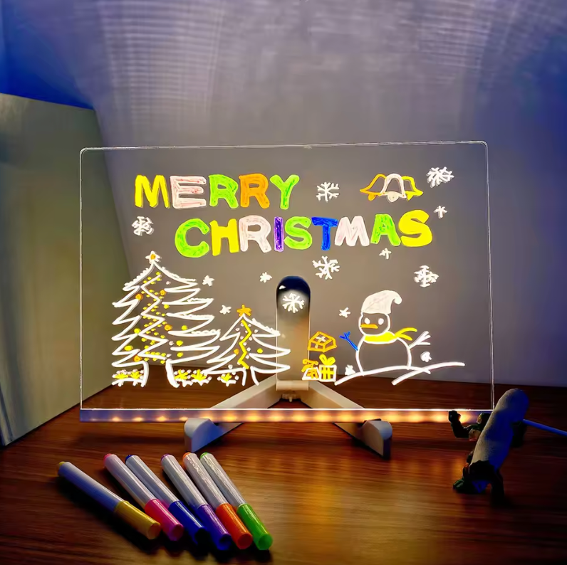 GlowSketch Board displaying illuminated Christmas scene with colorful markers, showing creative drawing capabilities on clear surface
