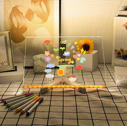 GlowSketch Board displaying illuminated spring flowers and sunflowers on transparent surface with colored markers on tiled surface