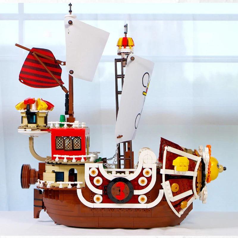 Grand Voyage pirate ship model with red and white sails, brown wooden hull, decorative details and multiple deck levels