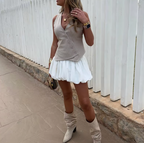 HighPeak Bubble Skirt in white paired with beige vest and knee-high boots, showcasing flowy bubble hem design and casual elegance