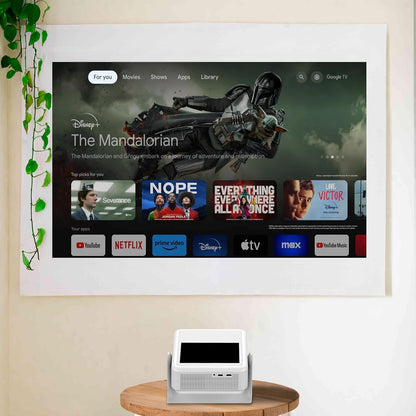 HighPeak FUSION projector displaying streaming apps interface on wall, with white smart tablet base on wooden table