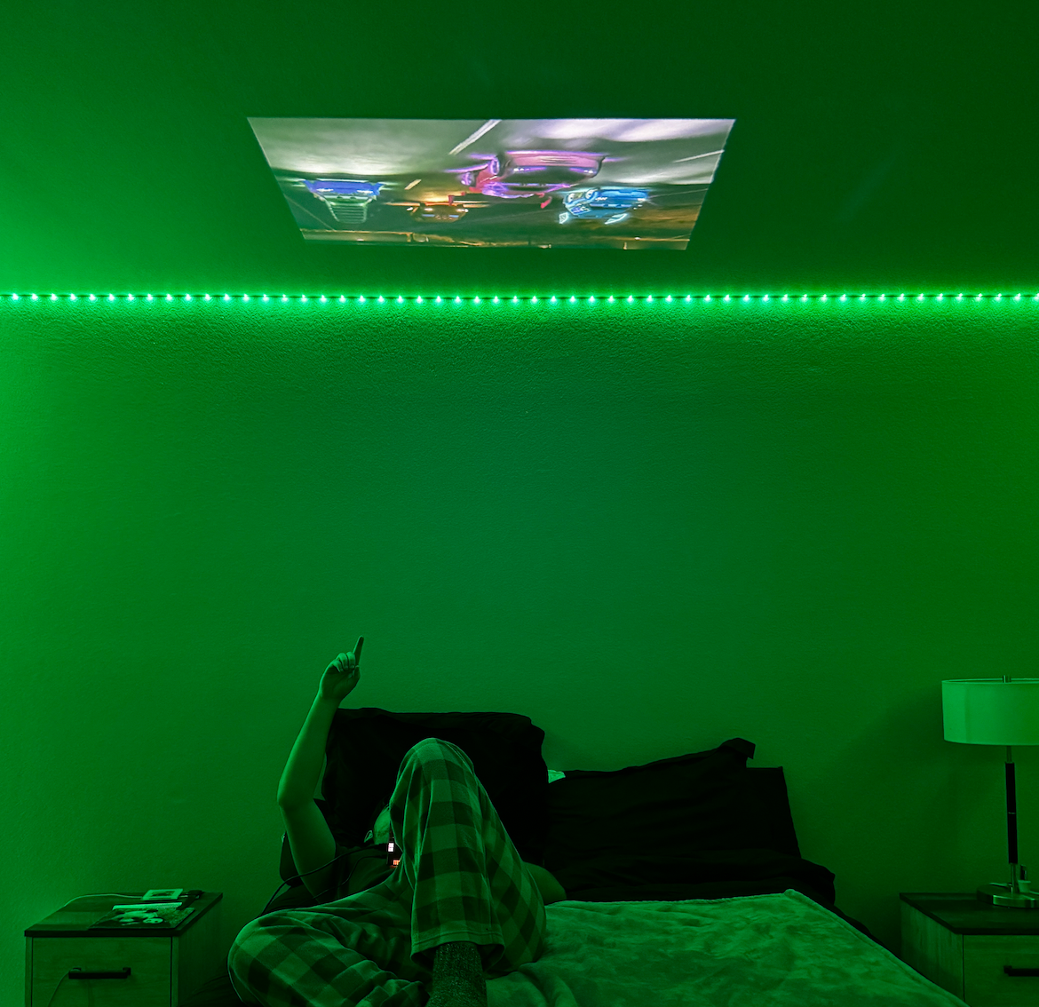 HighPeak INFINITY MiniProjector displaying vibrant content in dark room with green LED strip lighting and ceiling projection setup