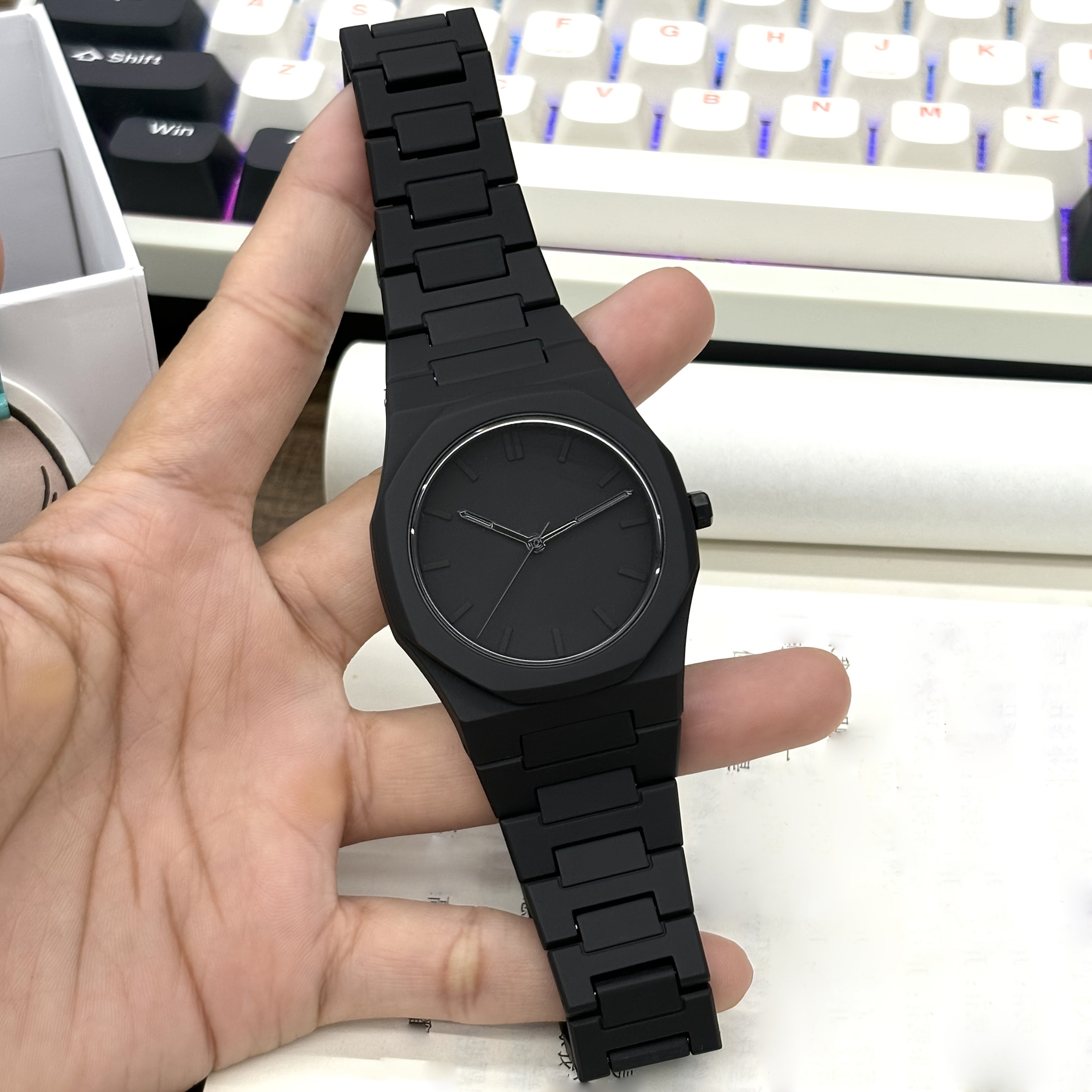 HighPeak Midnight Phantom watch in matte black stainless steel with minimalist dial displayed on a light keyboard background