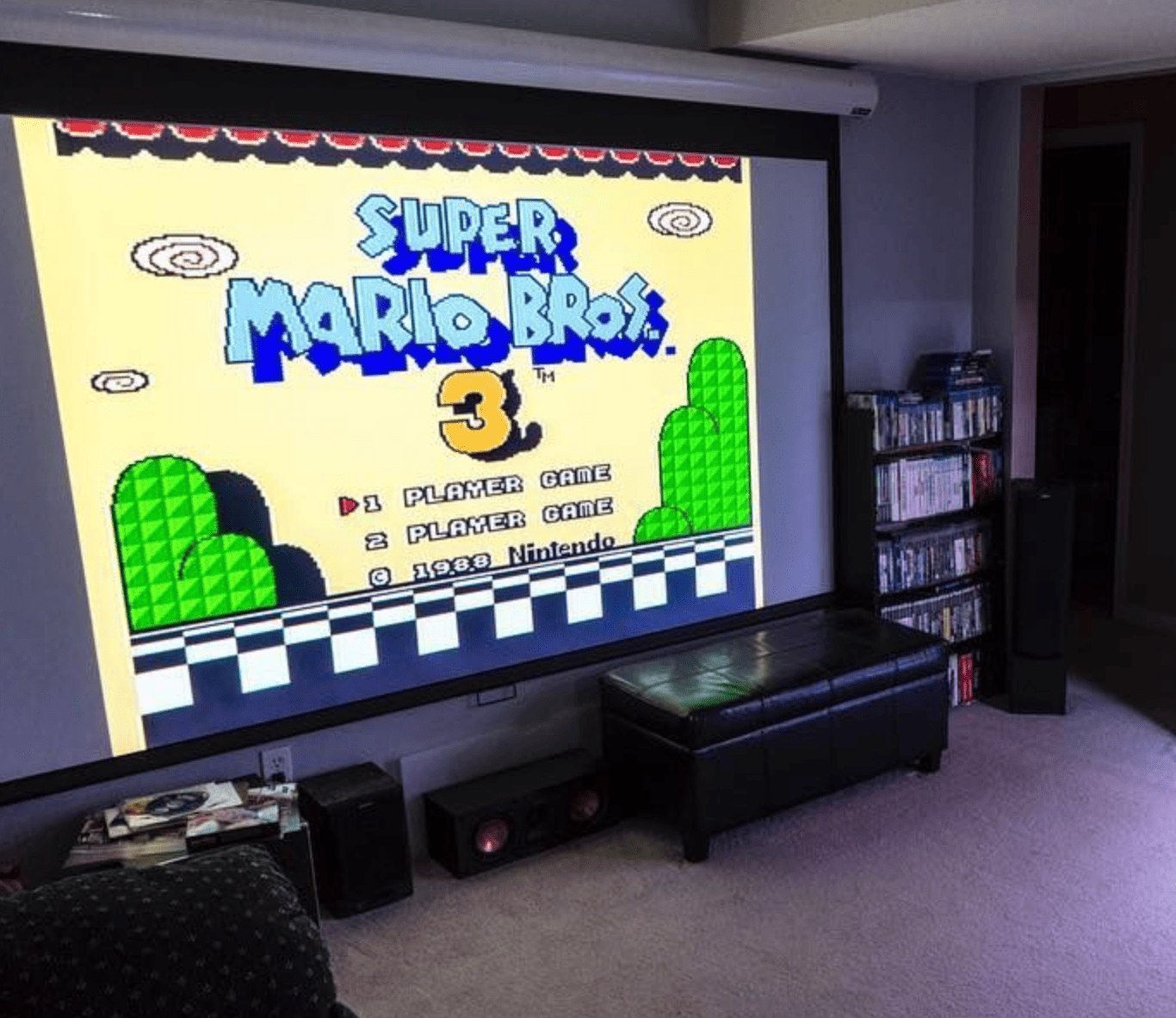 HighPeak MiniProjector SMART displaying Super Mario Bros 3 title screen on large wall projection in home gaming room setup