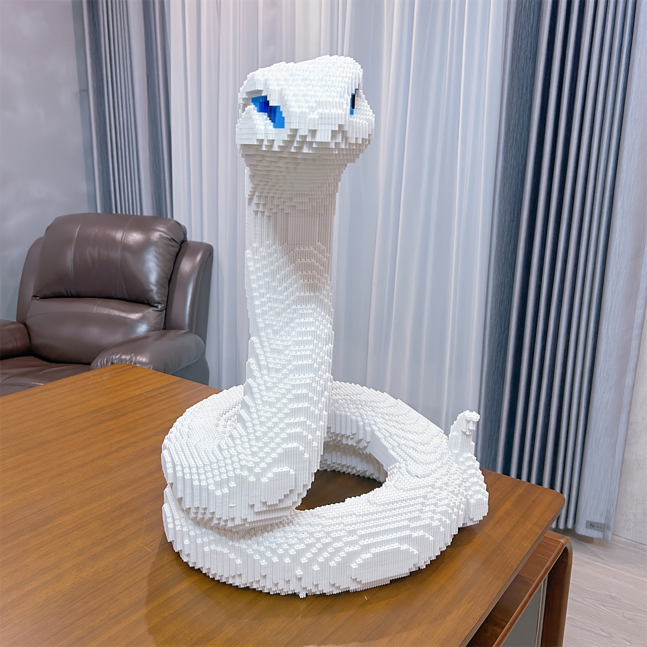 HighPeak SerpentMaster white coiled snake building set display with blue-accented eyes on wooden table - detailed 3D puzzle sculpture