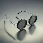 HighPeak ShiftLens round sunglasses with silver metal frame and black adjustable lenses on gradient gray background