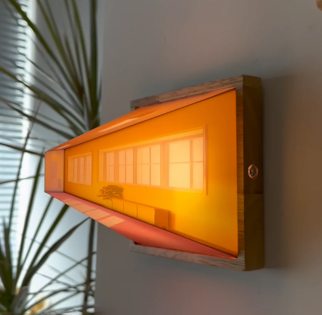 HighPeak Wallusion 3D illusion wall art in orange glow with wooden frame, creating depth effect near indoor palm plant