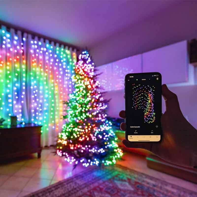 HolidayGlow Lights app-controlled rainbow LED display on Christmas tree with smartphone showing matching pattern control