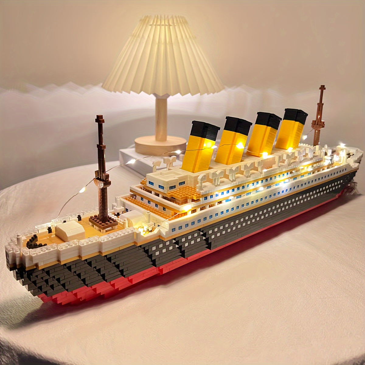 Illuminated Titanic Building Block Set displaying detailed yellow smokestacks and LED-lit decks on white display surface