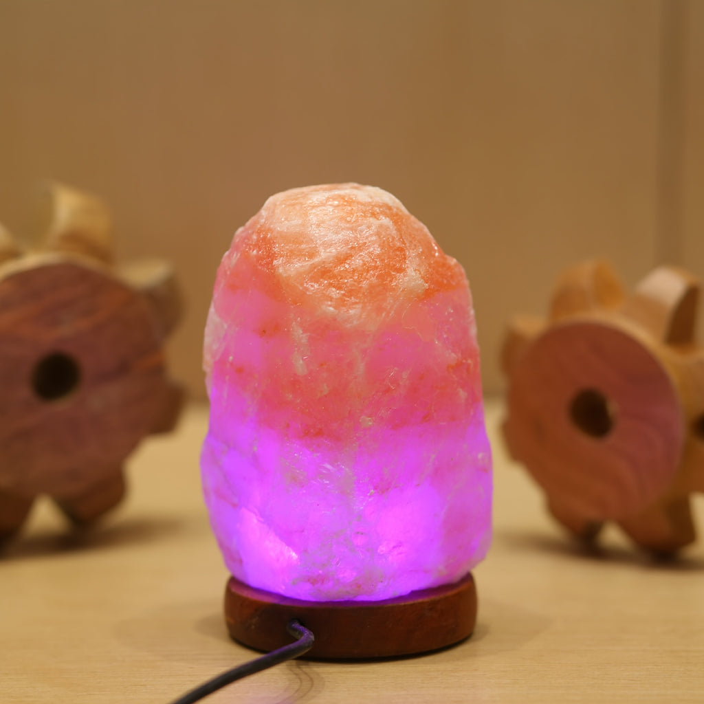 LumiStone Himalayan salt lamp glowing with vibrant purple LED light on wooden base - natural crystal home decor