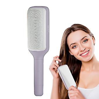 LuxeBrush self-cleaning hairbrush in lavender gray with white bristles shown in use for hair detangling and styling