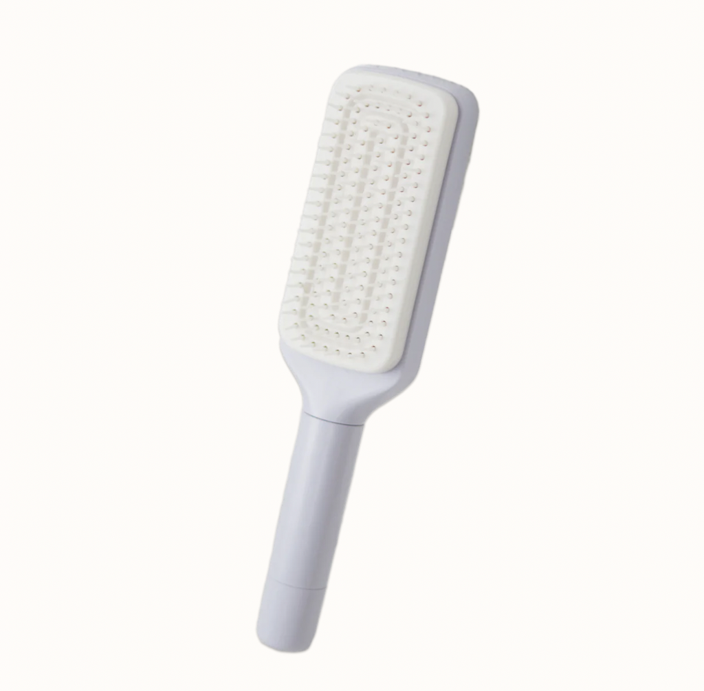 LuxeBrush self-cleaning hairbrush in white with rectangular paddle design and dense bristle arrangement on clean background