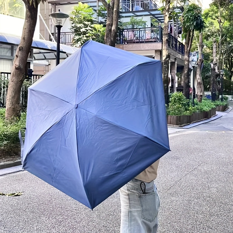 Mini Pocket Umbrella in navy blue shown opened on urban street, demonstrating compact foldable design for everyday use