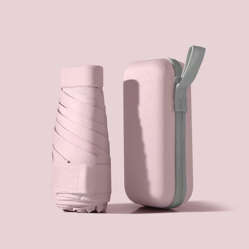 Mini Pocket Umbrella in pastel pink with matching hard case, folded compact design showing protective sleeve and carrying strap