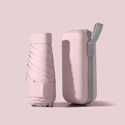 Mini Pocket Umbrella in pastel pink with matching hard case, folded compact design showing protective sleeve and carrying strap